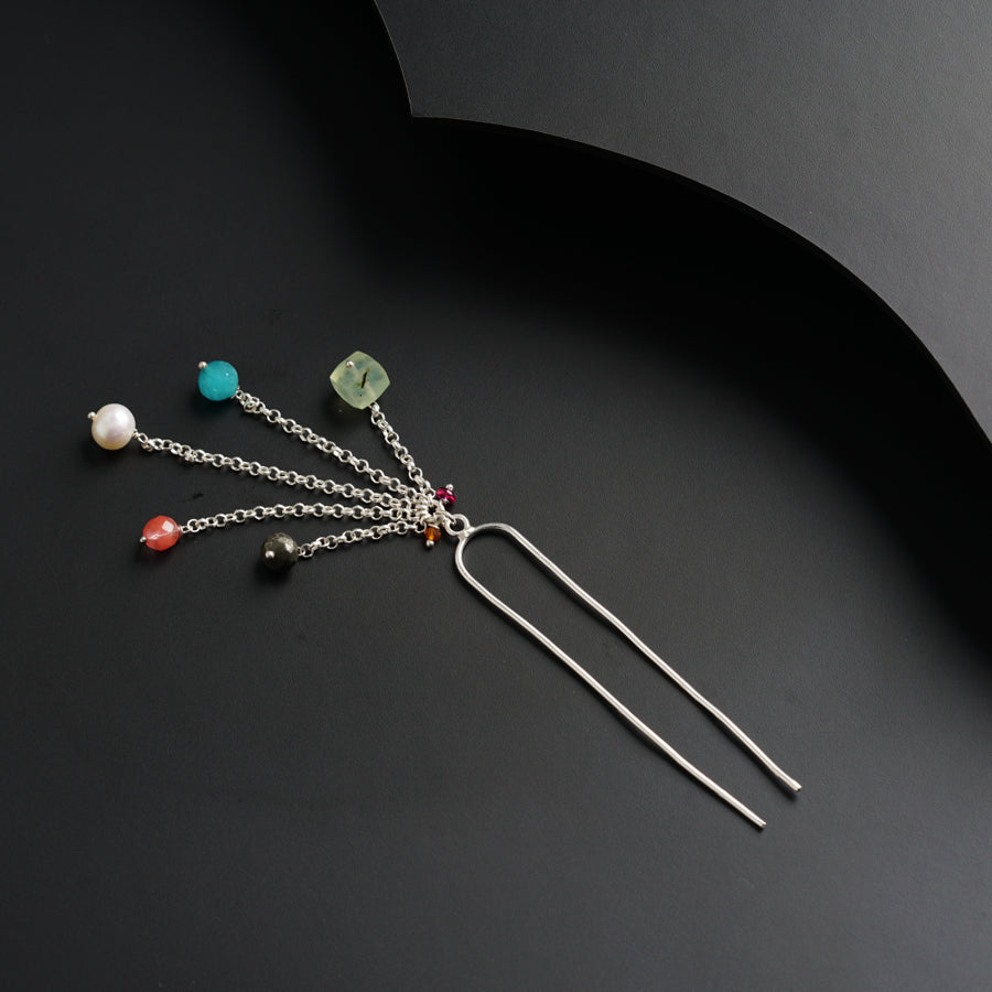 a bunch of different colored beads hanging from a metal hook