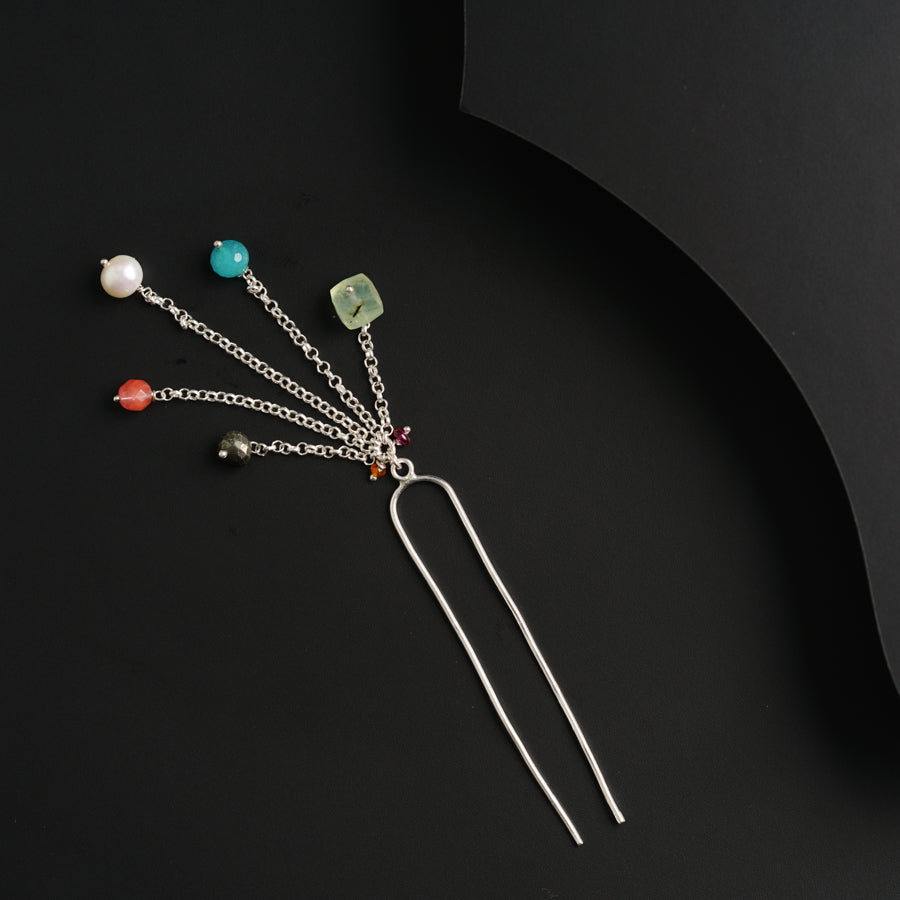 a set of five hair pins sitting on top of a black surface