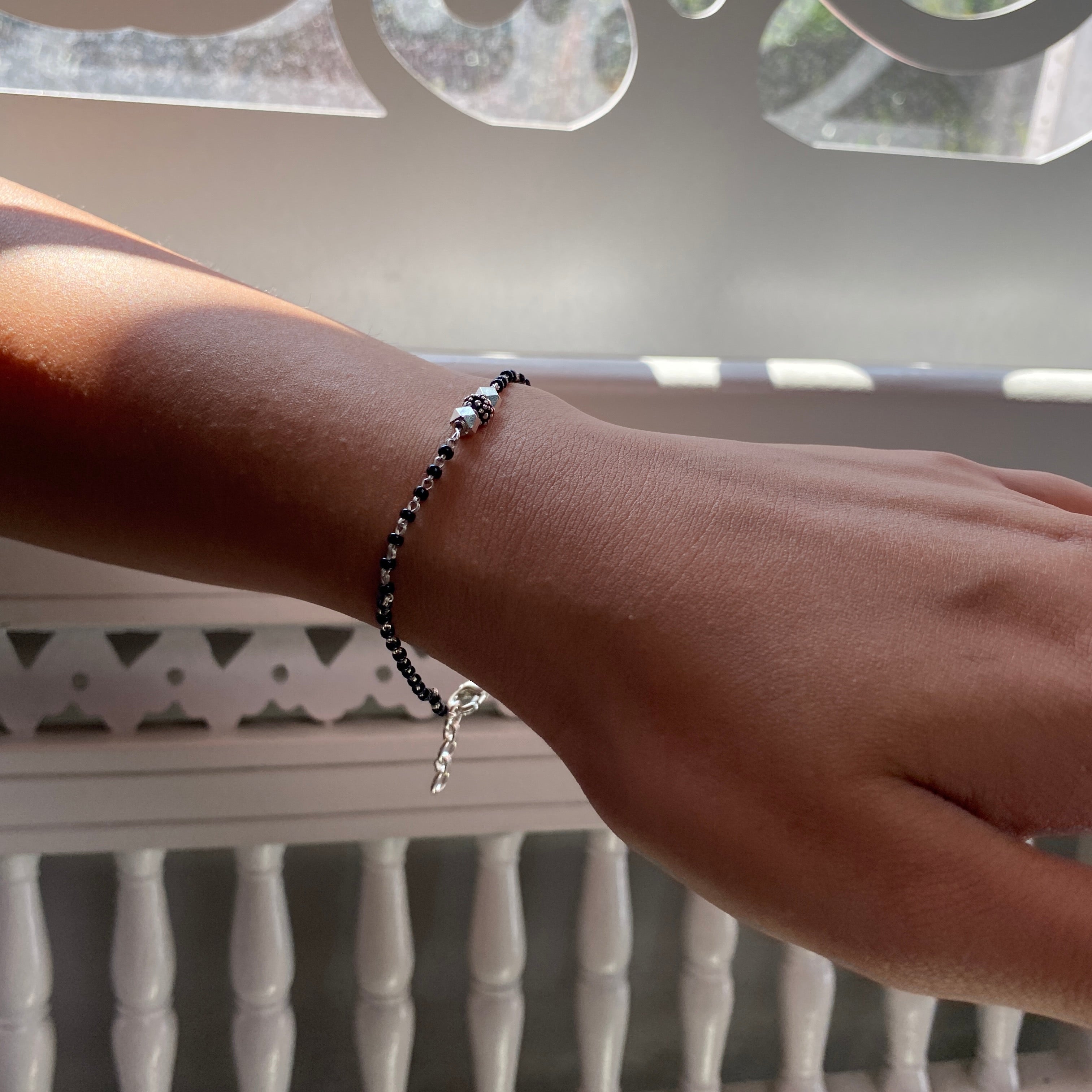 a person wearing a bracelet with a cross on it