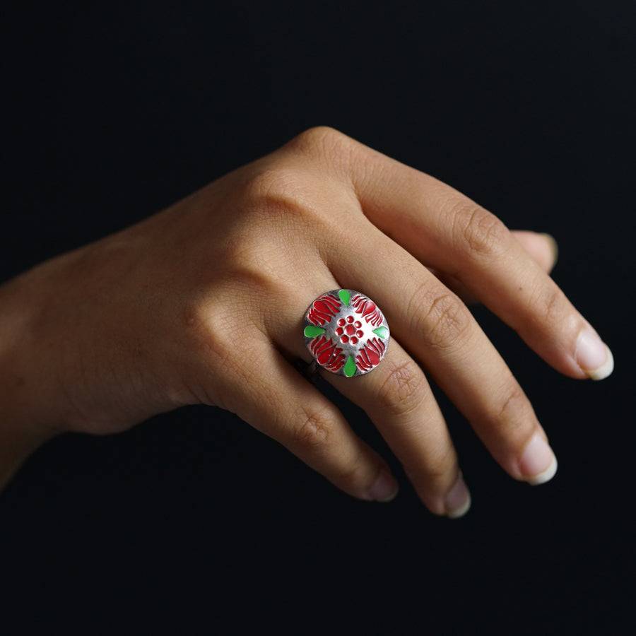 a woman's hand with a ring decorated with flowers