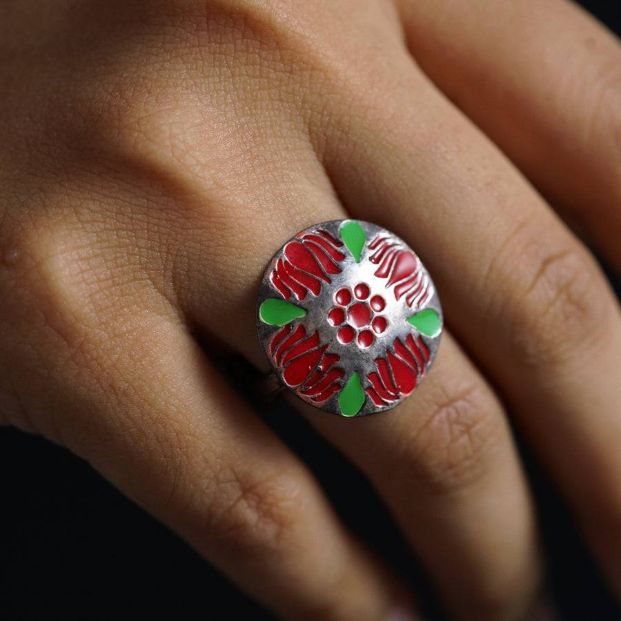 a woman's hand with a ring decorated with flowers