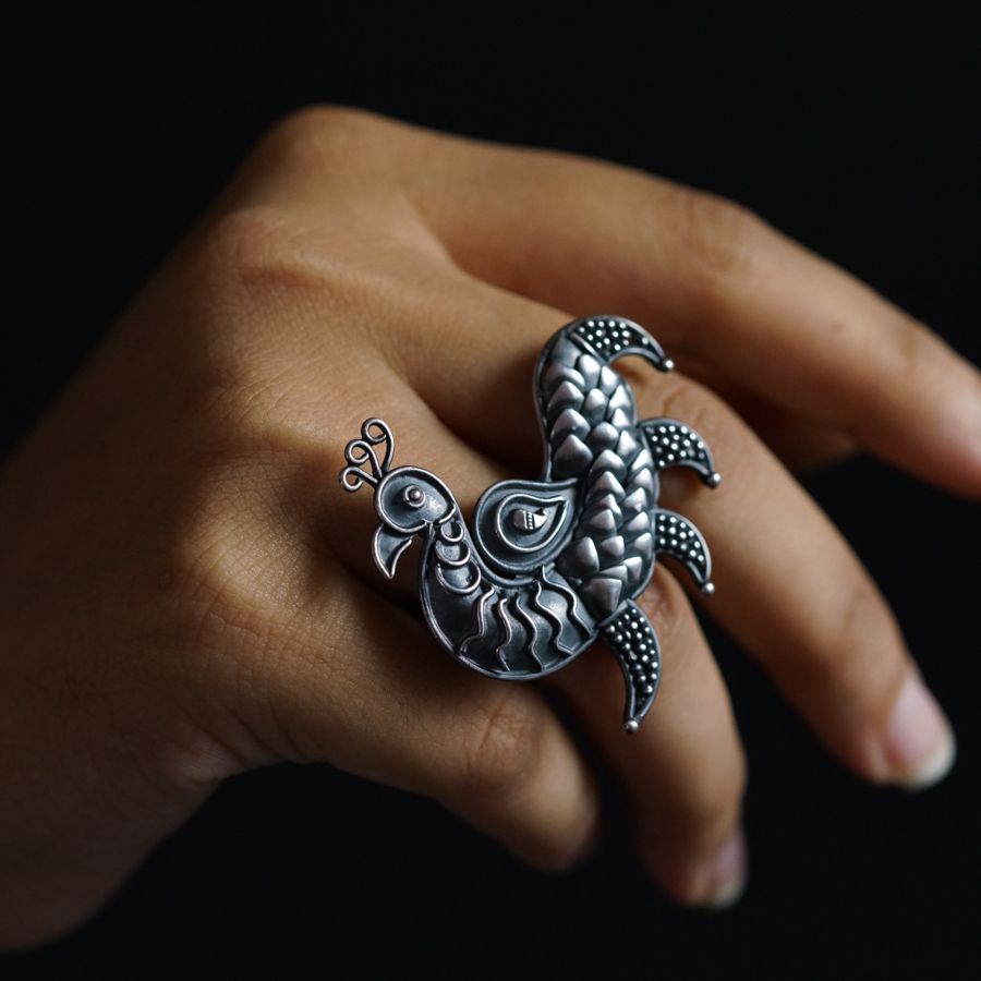 a woman's hand wearing a ring with a sea turtle on it