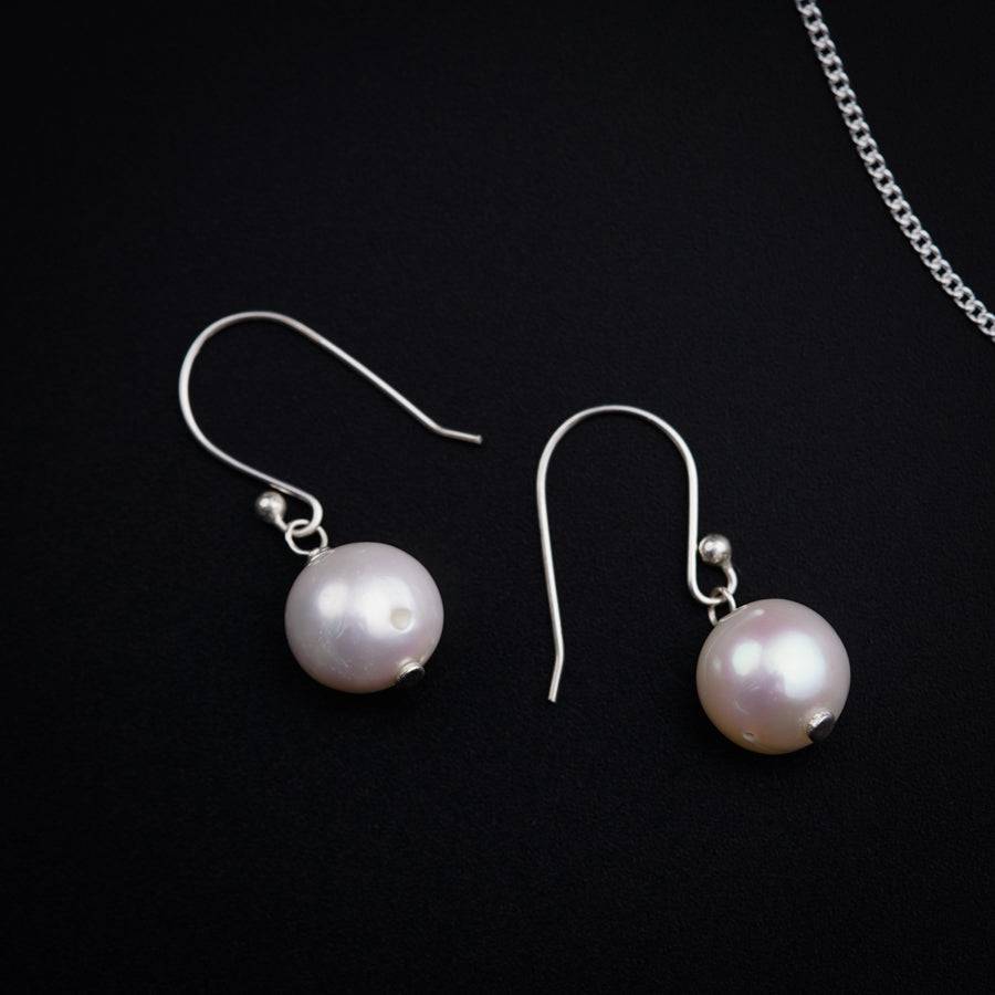 a pair of earrings and a chain on a black background