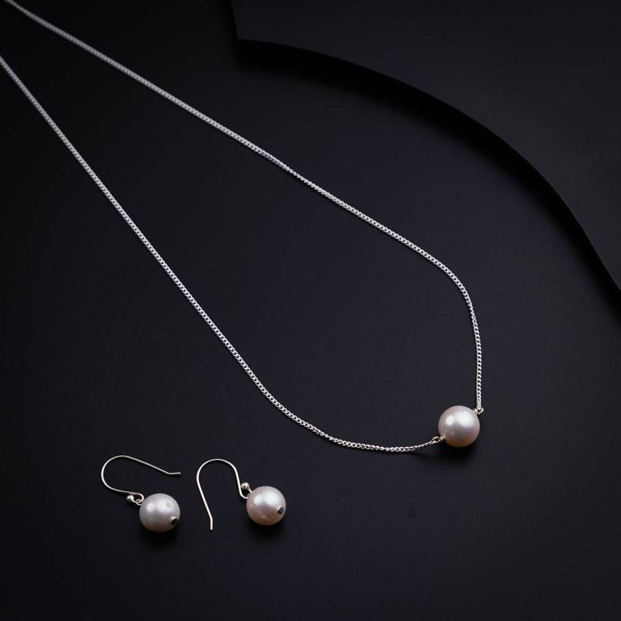 a necklace and earrings on a black surface