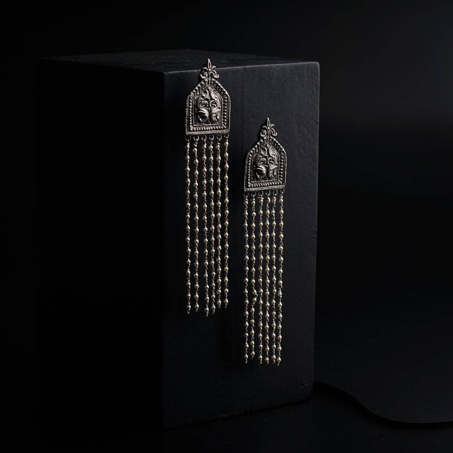 a pair of earrings on a black background