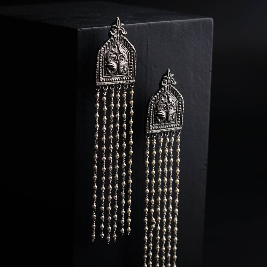 a pair of earrings with beads hanging from it