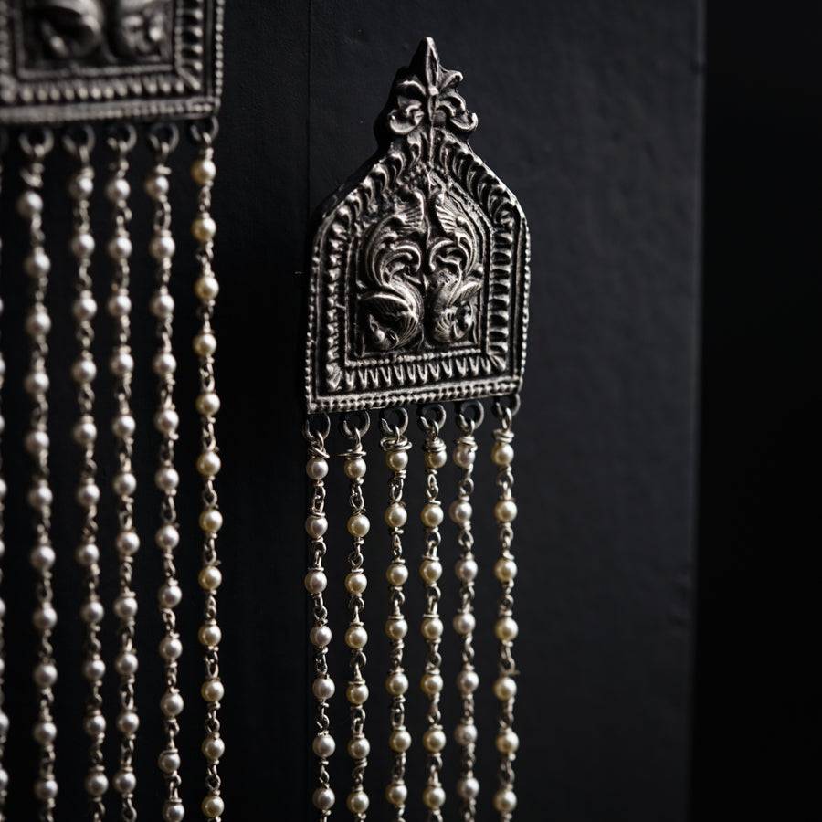 a pair of earrings hanging from a wall