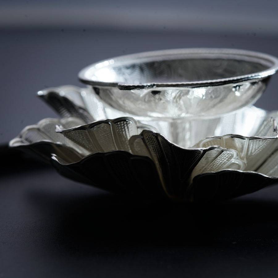 a silver bowl sitting on top of a black table