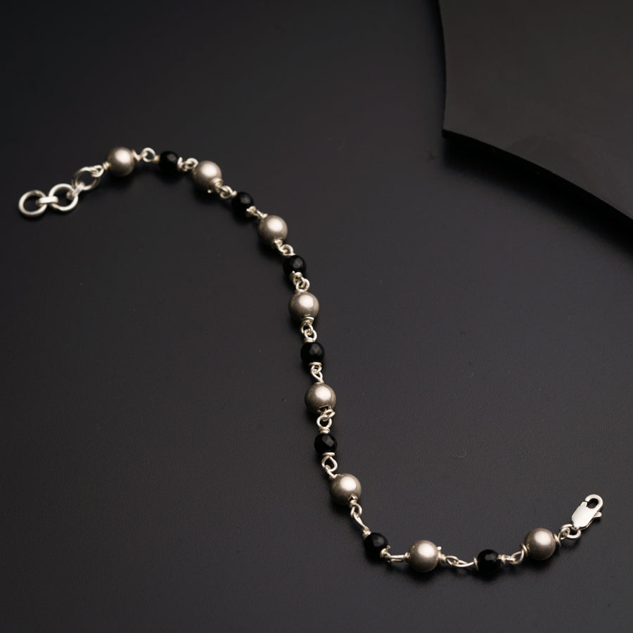 a black and white beaded necklace on a black surface