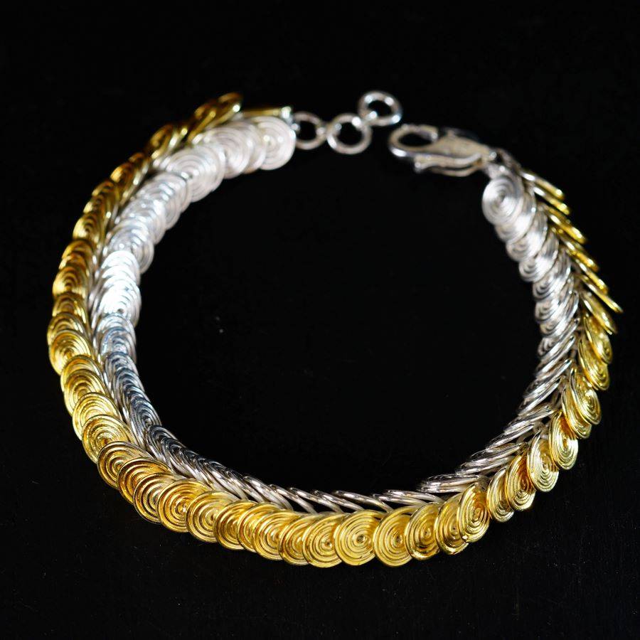 a gold and silver bracelet on a black background