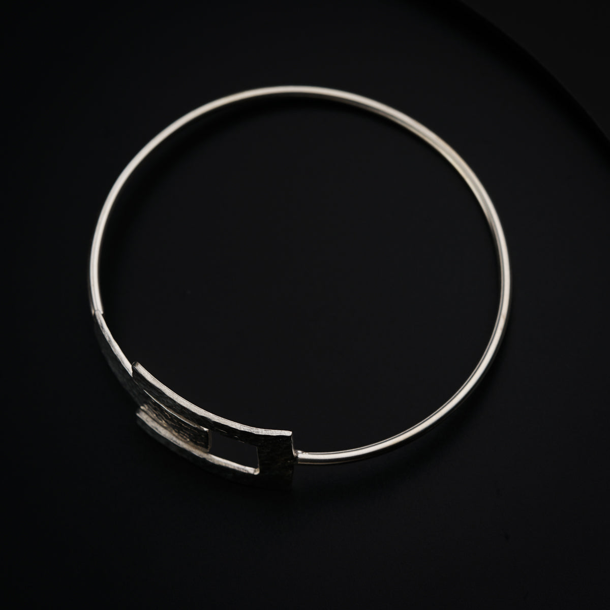 a close up of a metal bracelet on a black surface