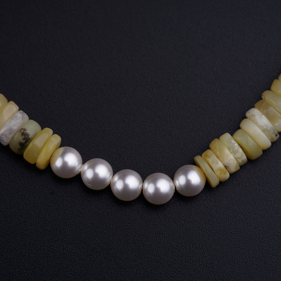 a necklace made of pearls and yellow agate beads