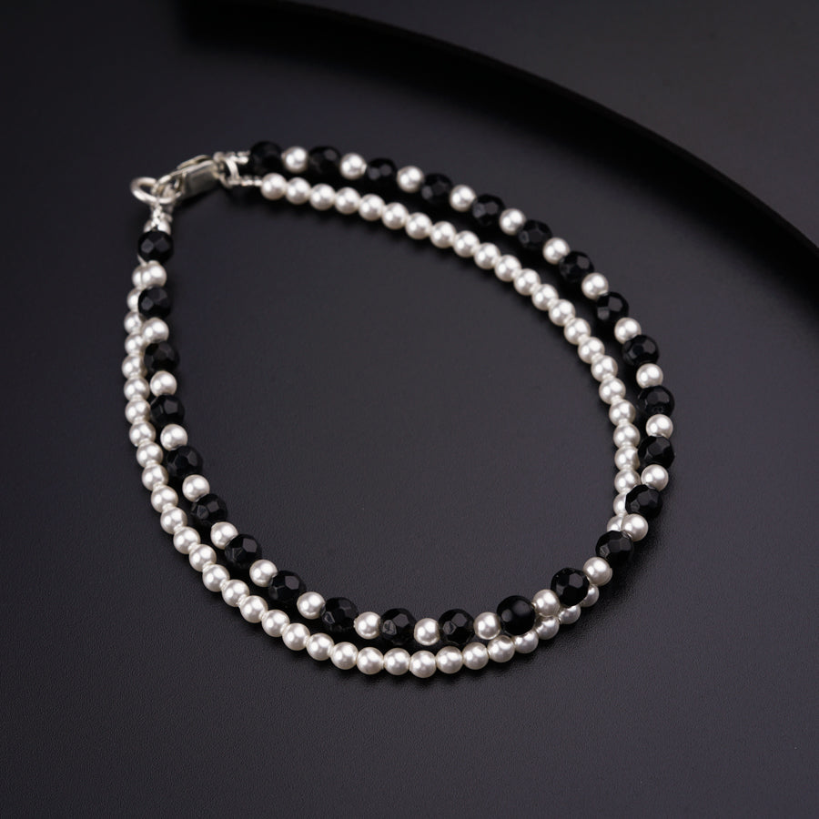 a black and white beaded bracelet with silver beads