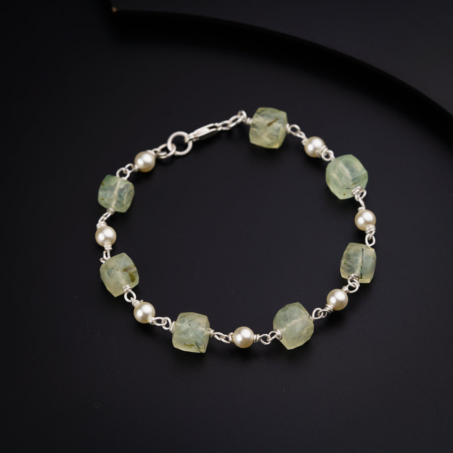 a bracelet with pearls and green glass beads