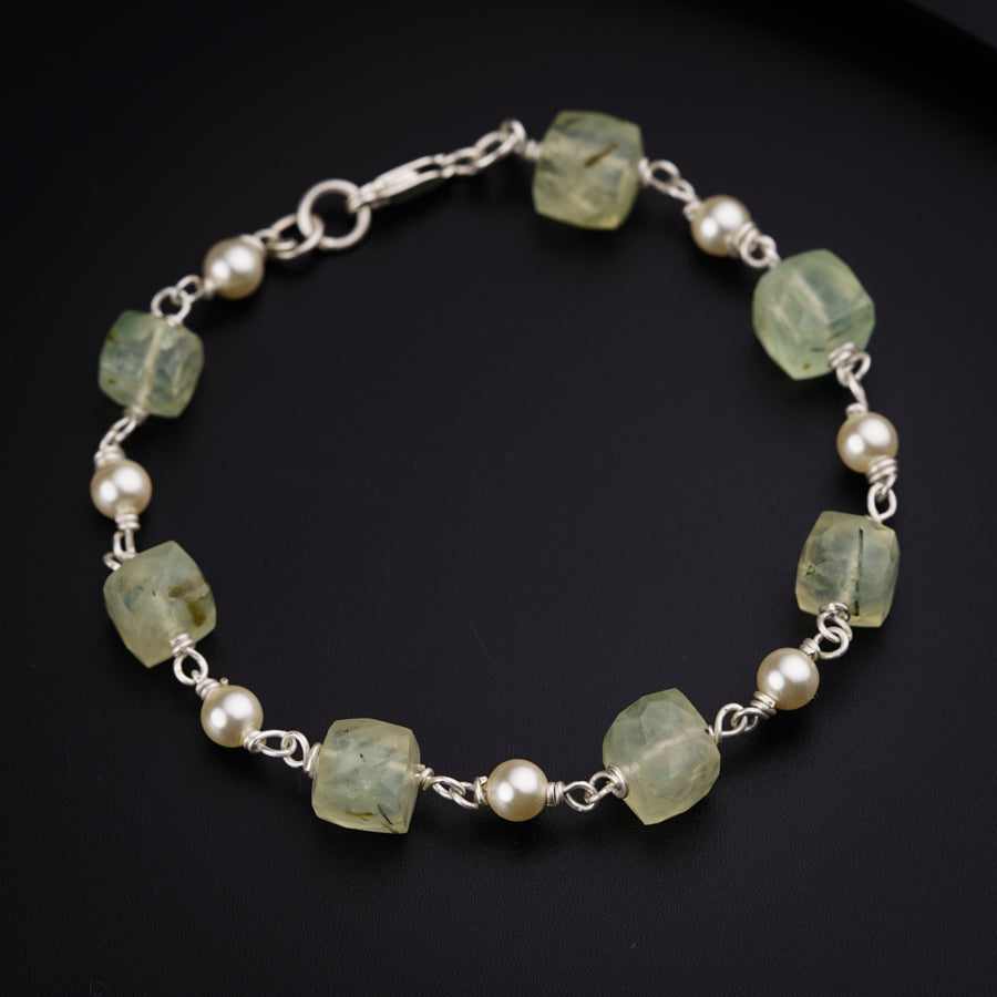 a bracelet with pearls and green glass beads