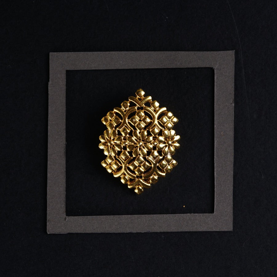 a picture of a gold brooch on a black background