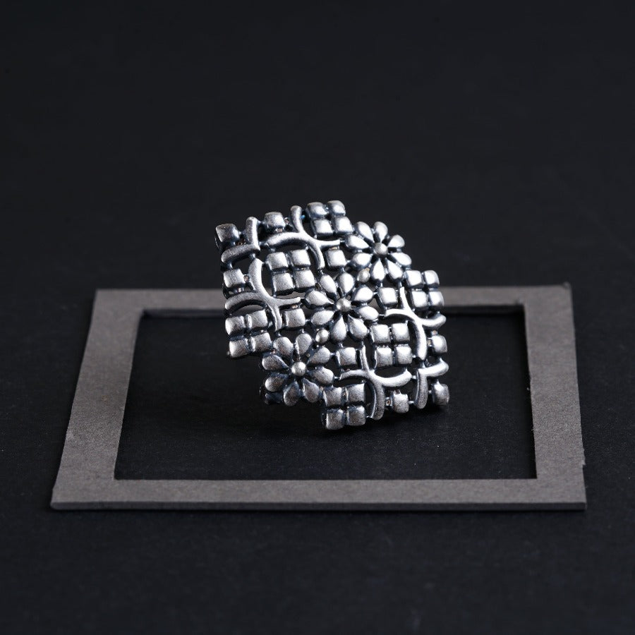 a silver ring sitting on top of a black surface