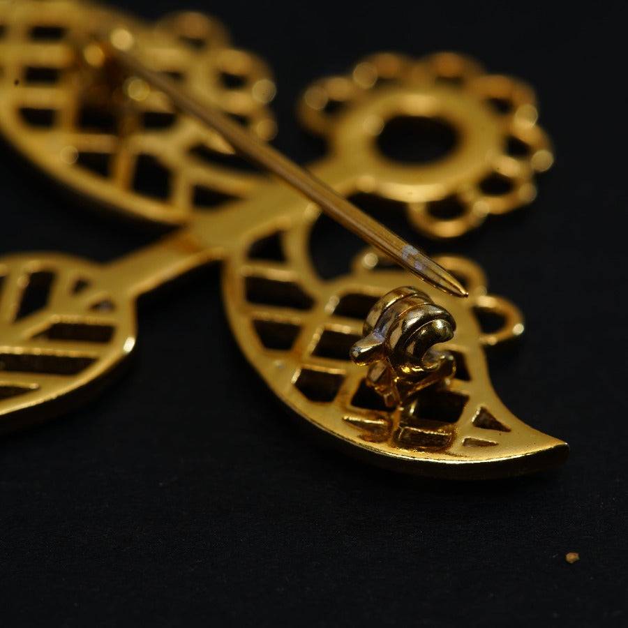 a close up of a gold brooch