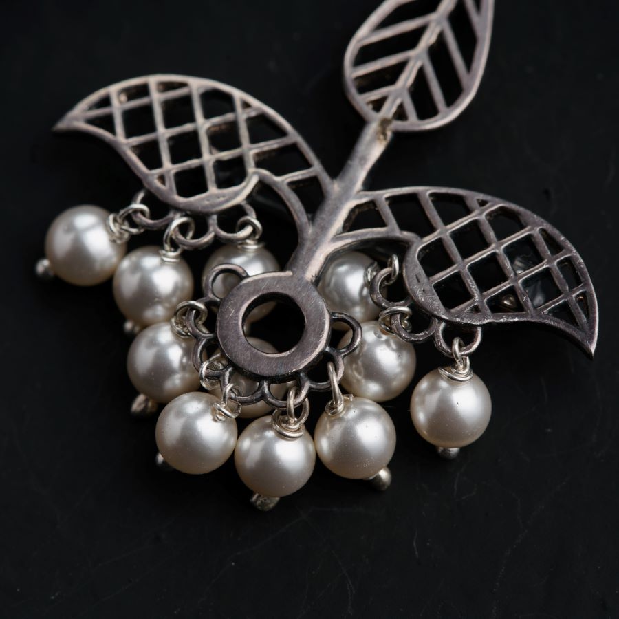 a brooch with a bunch of pearls attached to it