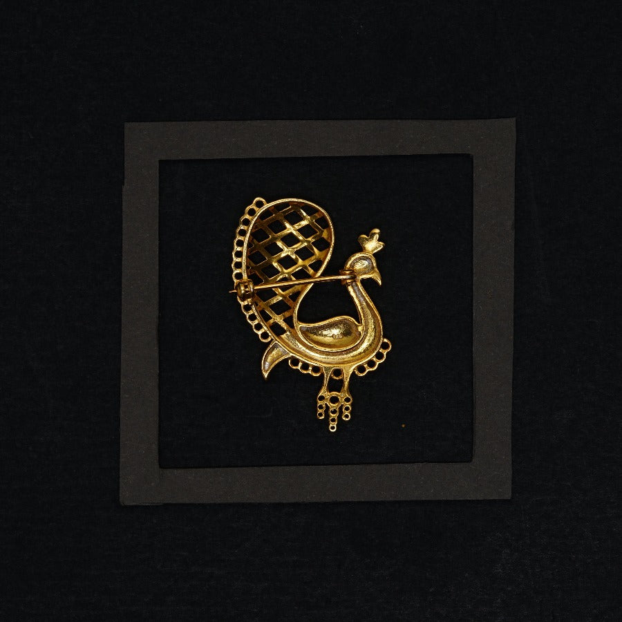 a gold brooch with a bird on it