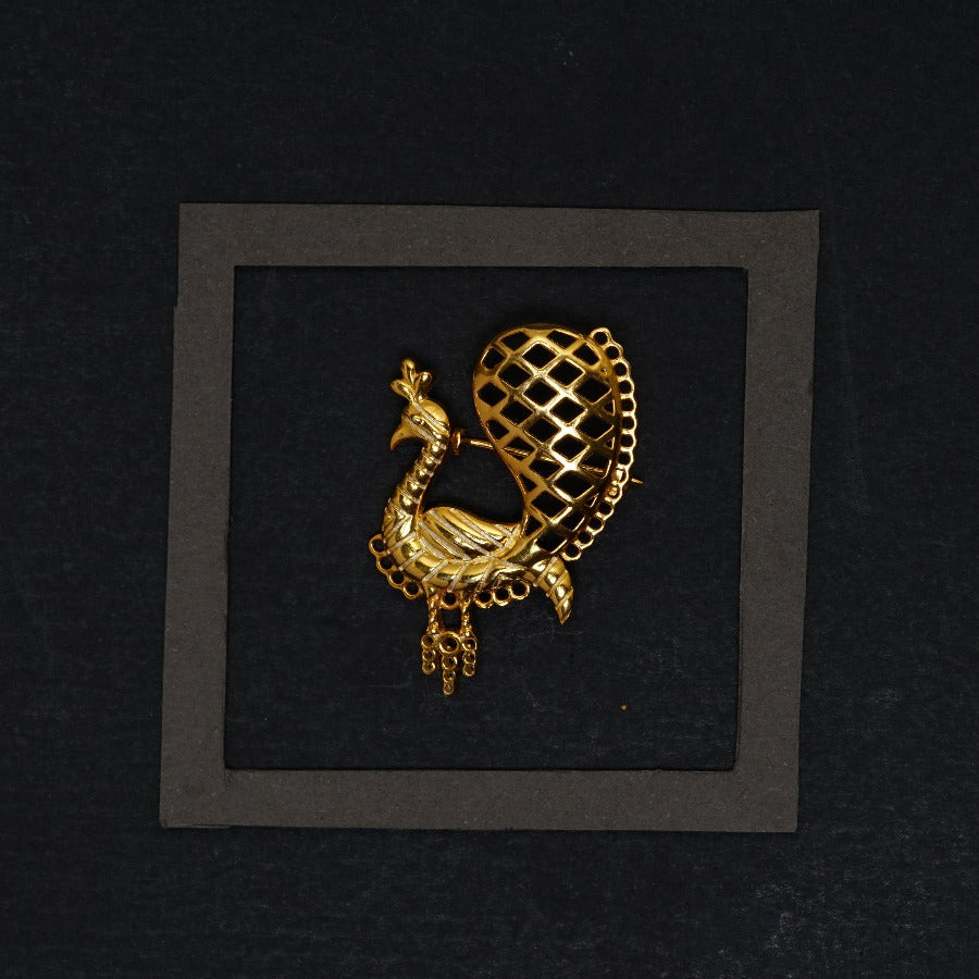 a gold brooch with a bird on it