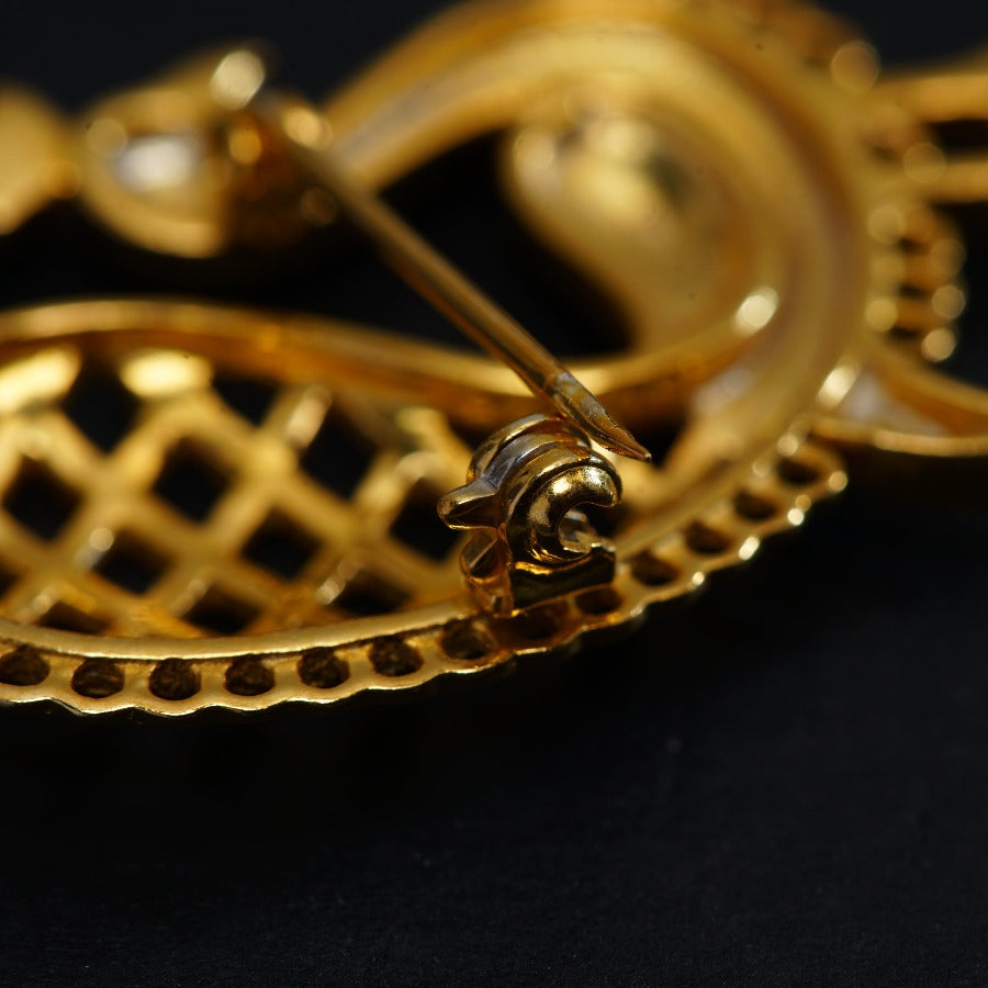 a close up of a gold object on a black surface