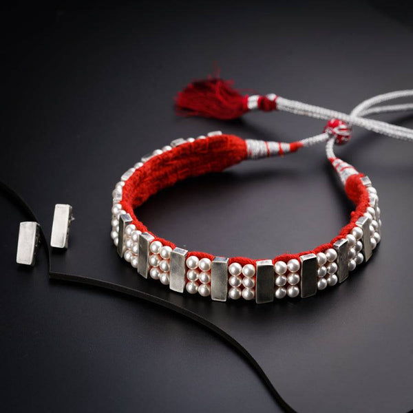 a red string bracelet with silver beads and tassels