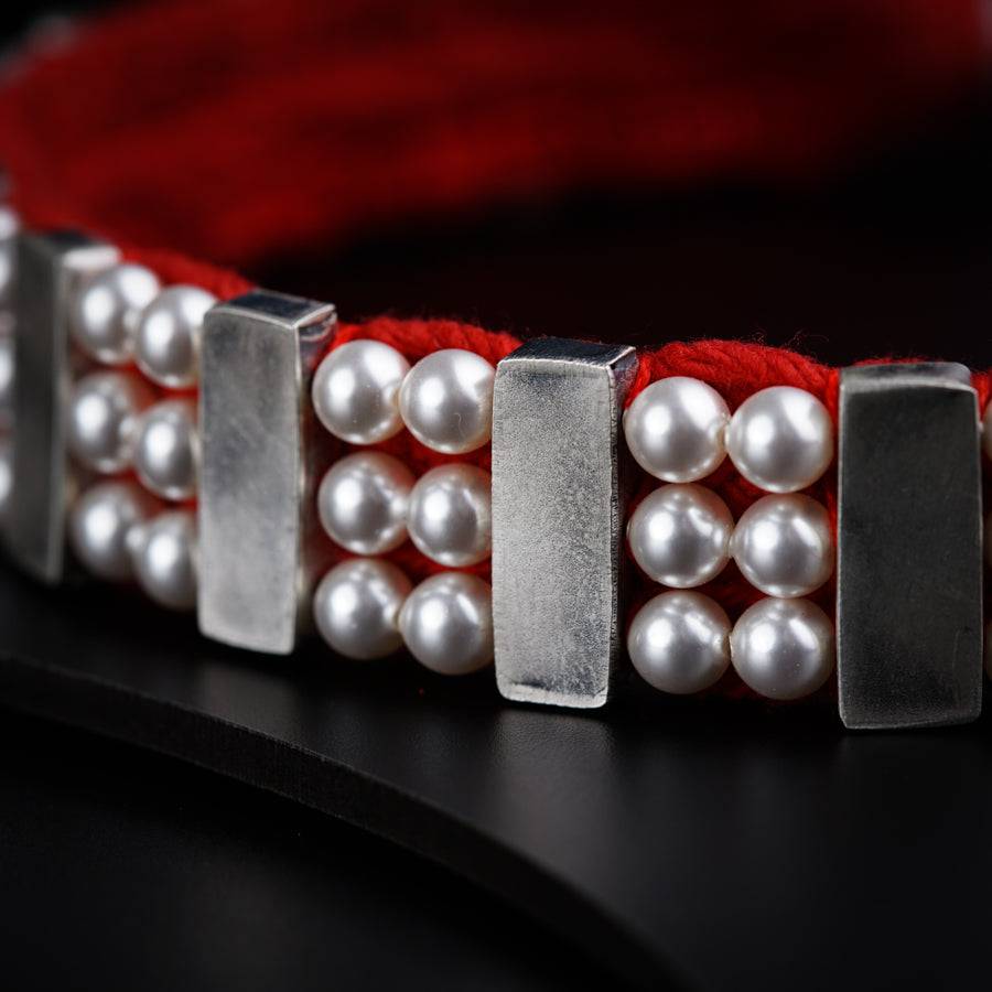 a close up of a bracelet with pearls