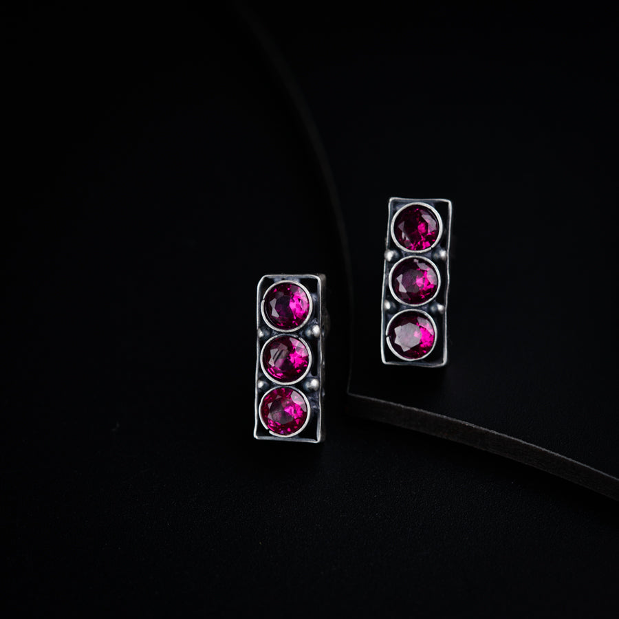 a pair of pink earrings sitting on top of a black surface