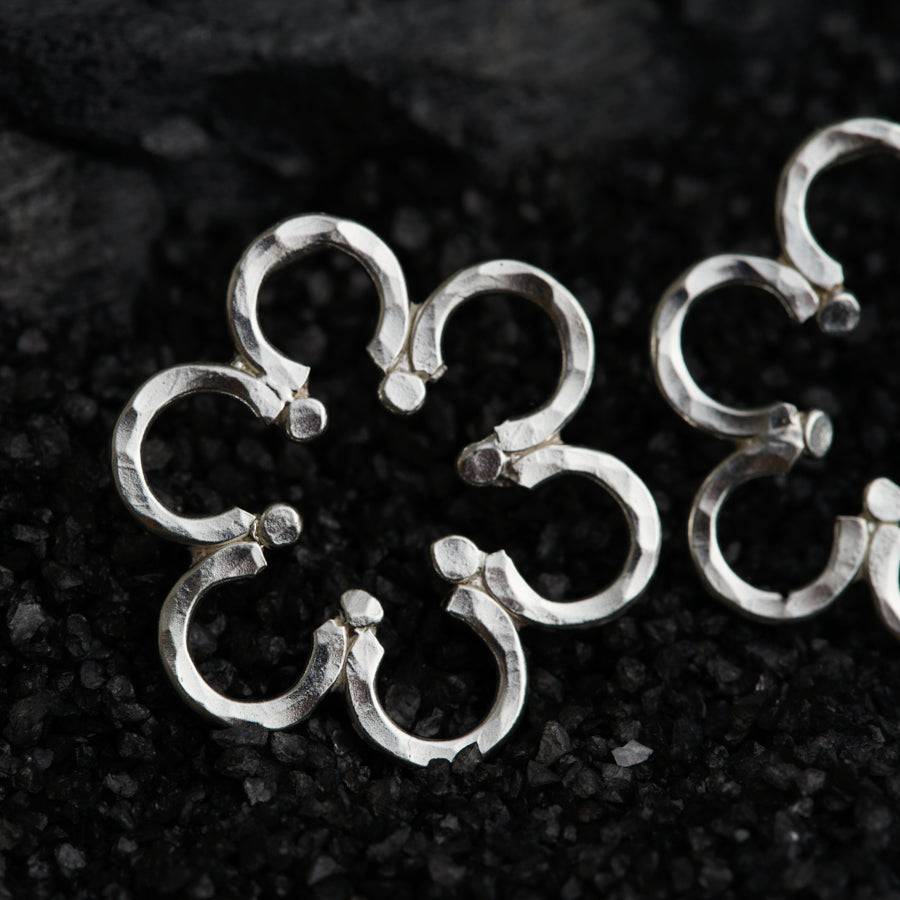 a group of silver rings sitting on top of a black surface