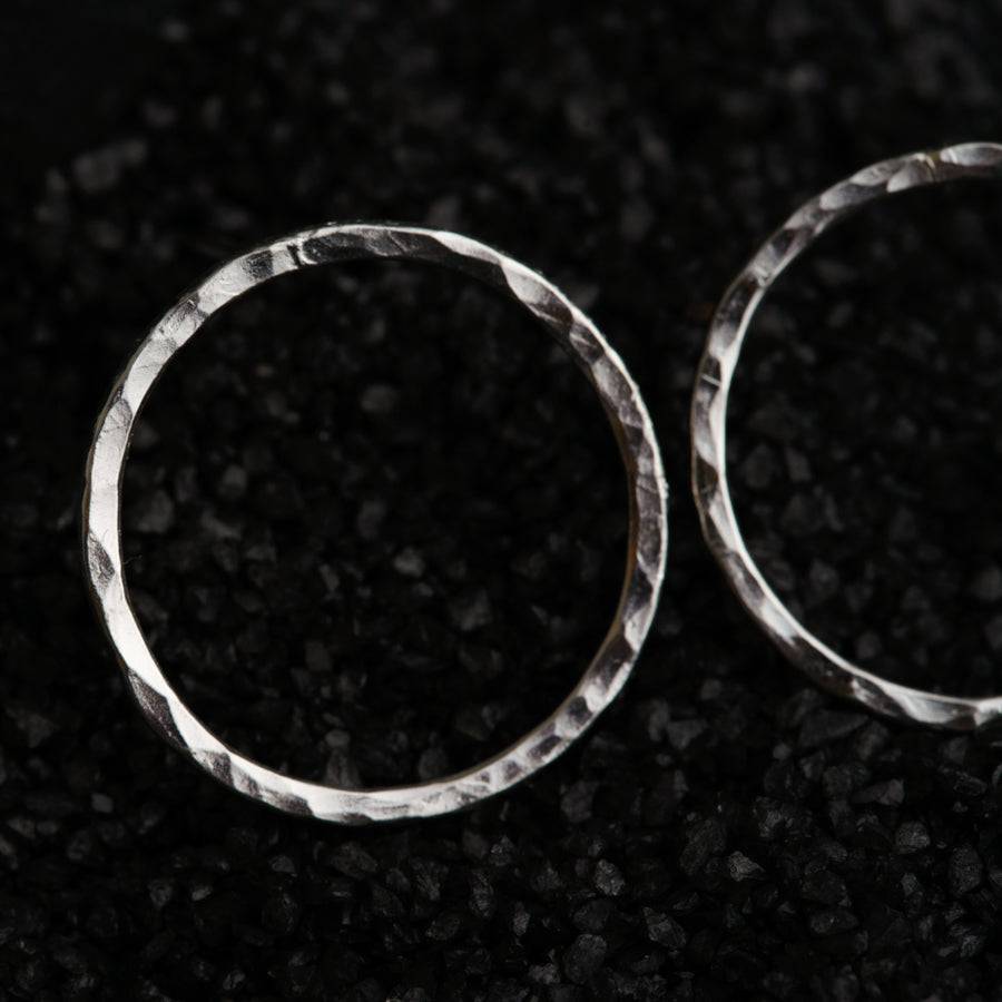 a pair of silver rings sitting on top of a black surface
