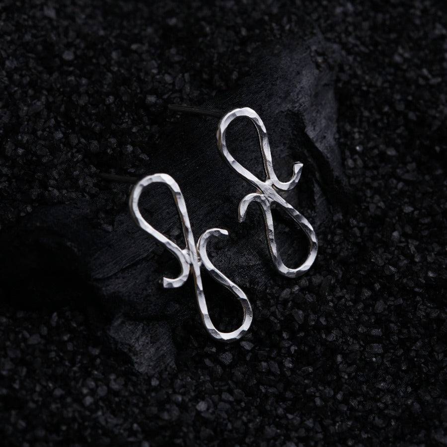 a pair of silver scissors sitting on top of a black surface