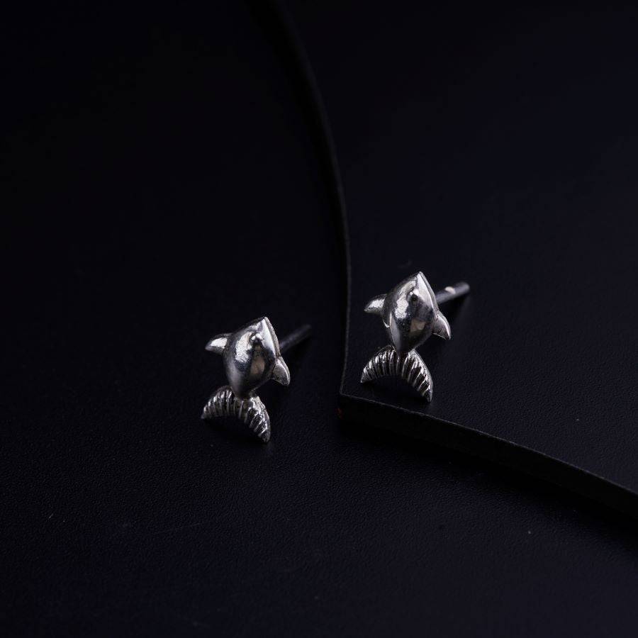 a pair of earrings sitting on top of a black surface