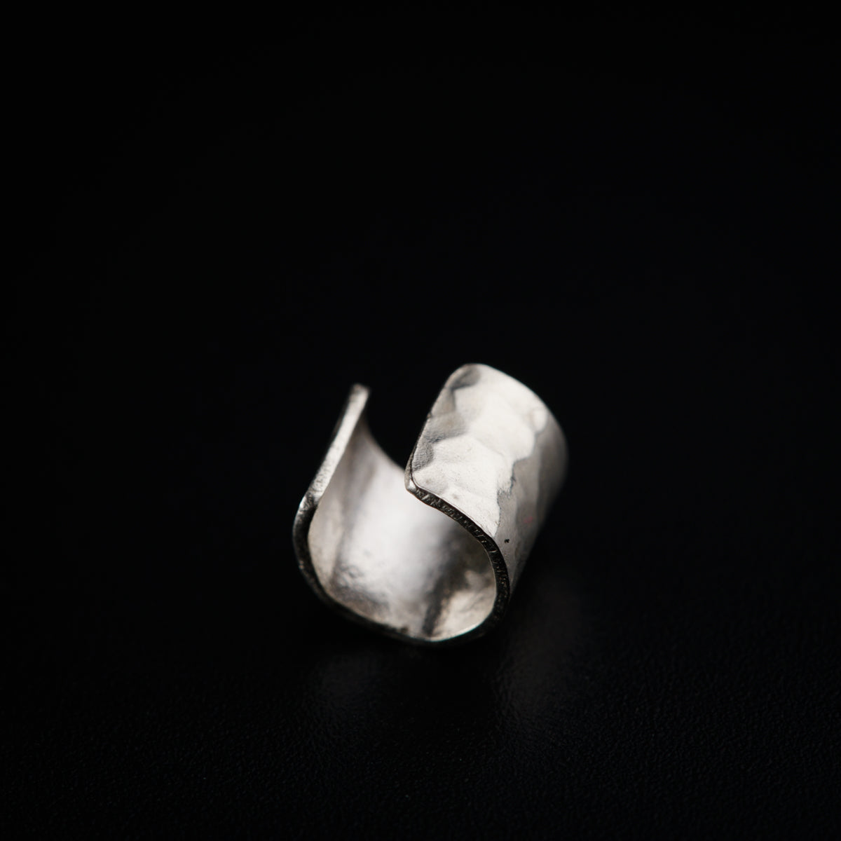 a close up of a silver ring on a black surface