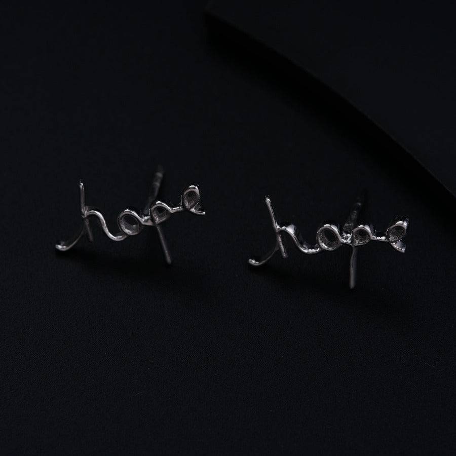 a pair of earrings with the word hope written on them