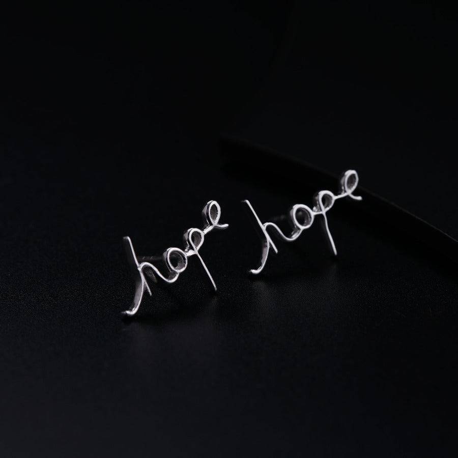 a pair of earrings with the word hope written on them