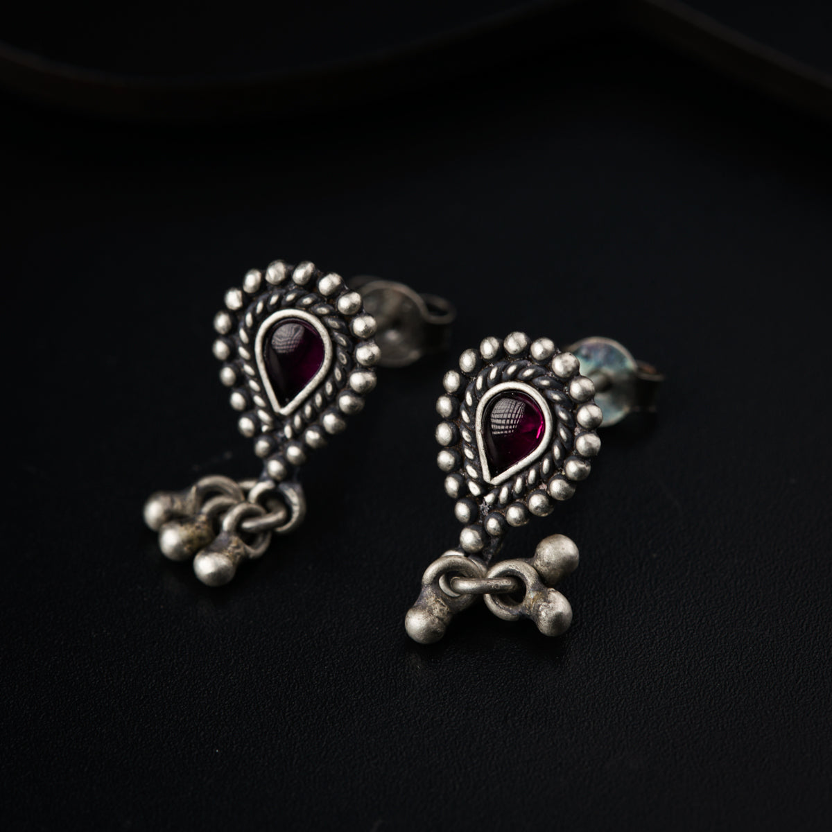 a pair of silver earrings with a heart shaped design