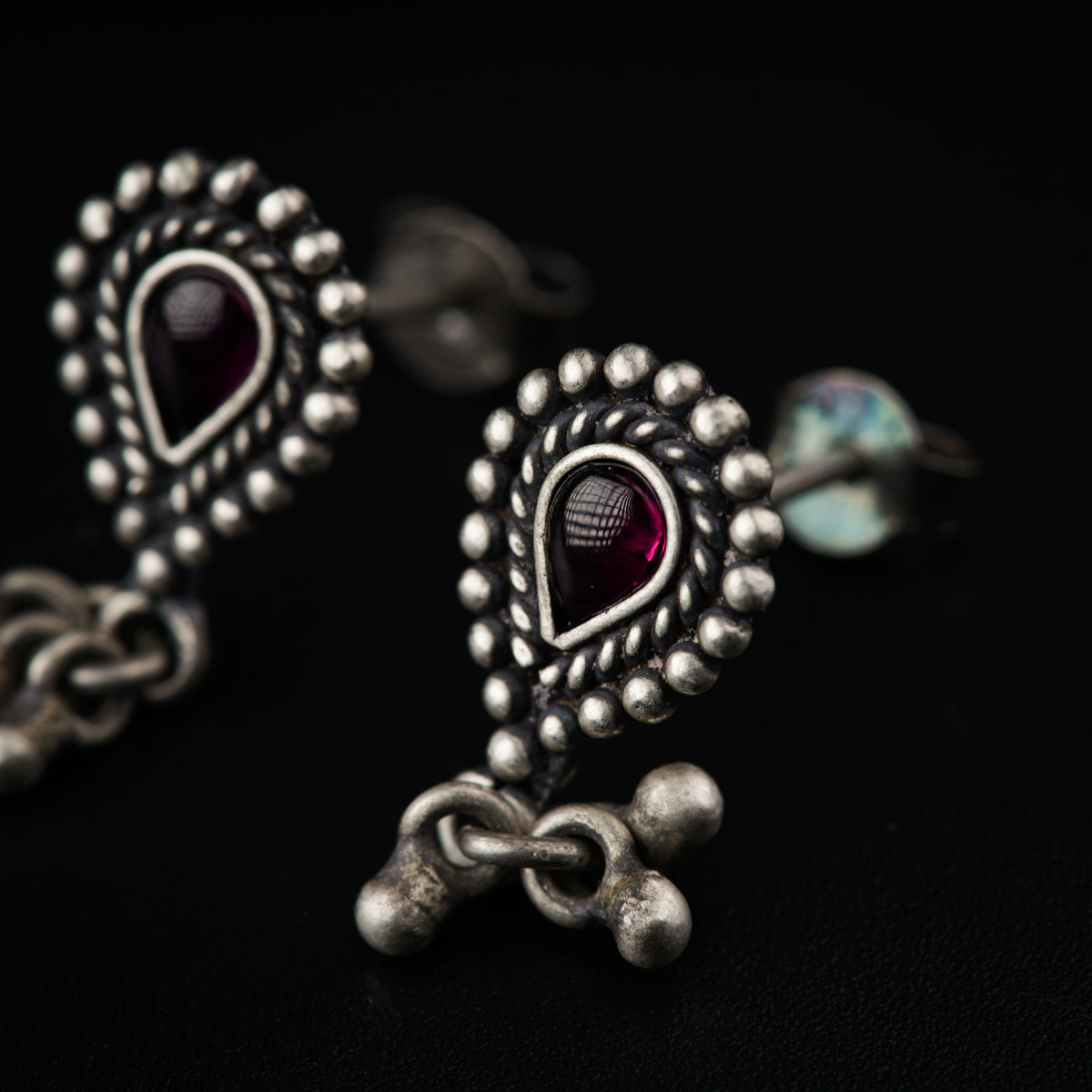 a close up of a pair of earrings on a black surface