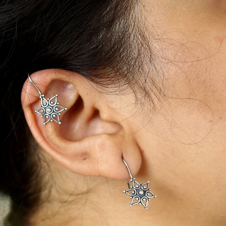 a close up of a person wearing a pair of earrings