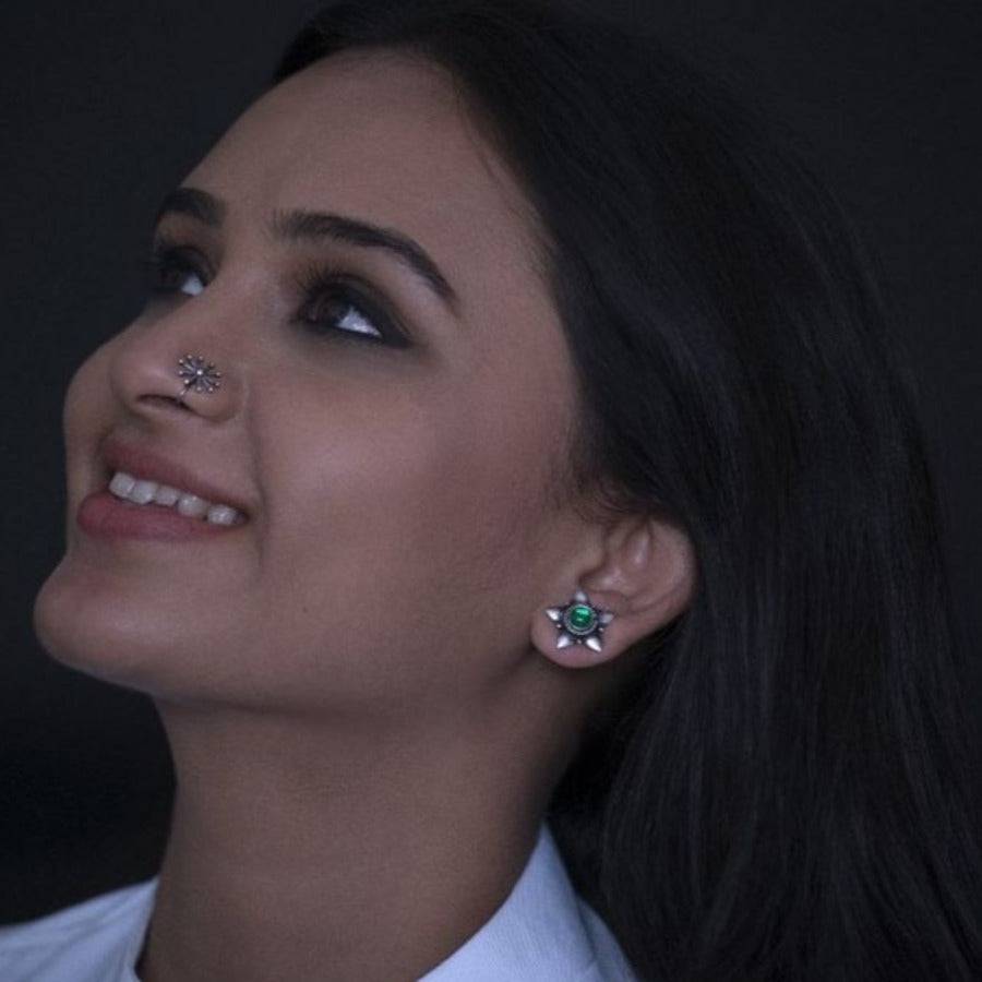 a close up of a person wearing a shirt and a pair of earrings