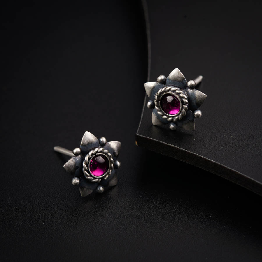 a pair of silver and pink stone earrings