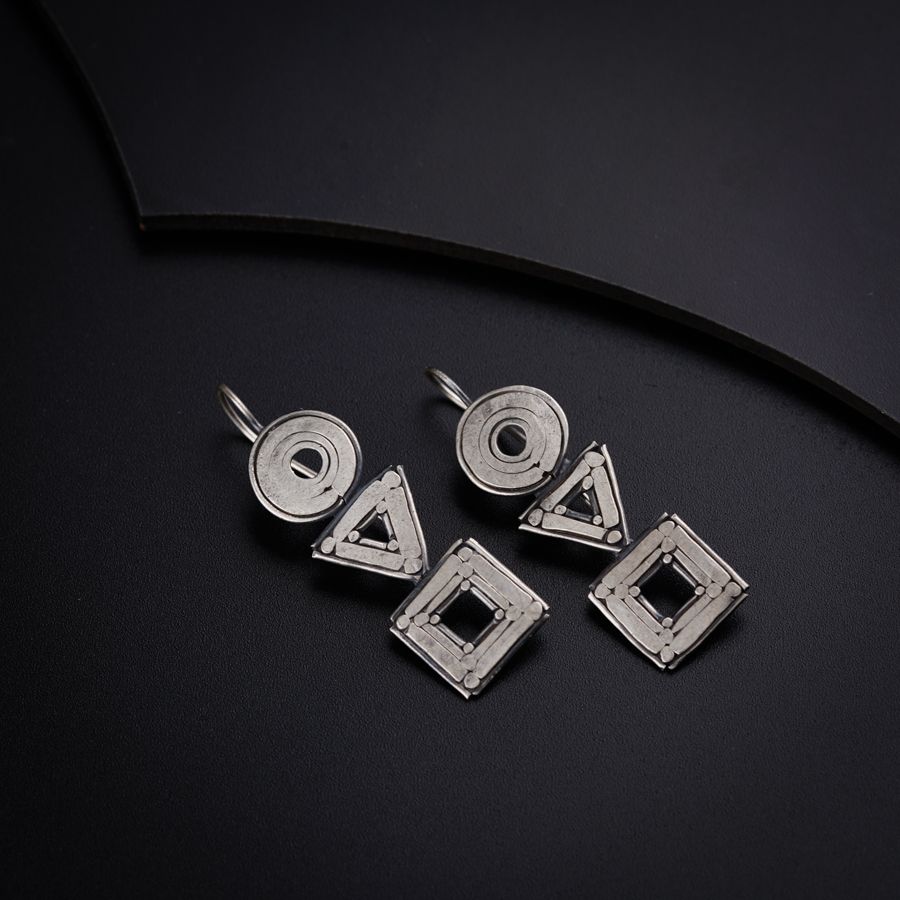 three pieces of metal sitting on top of a black surface