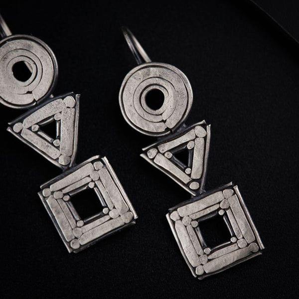 a pair of silver earrings sitting on top of a table