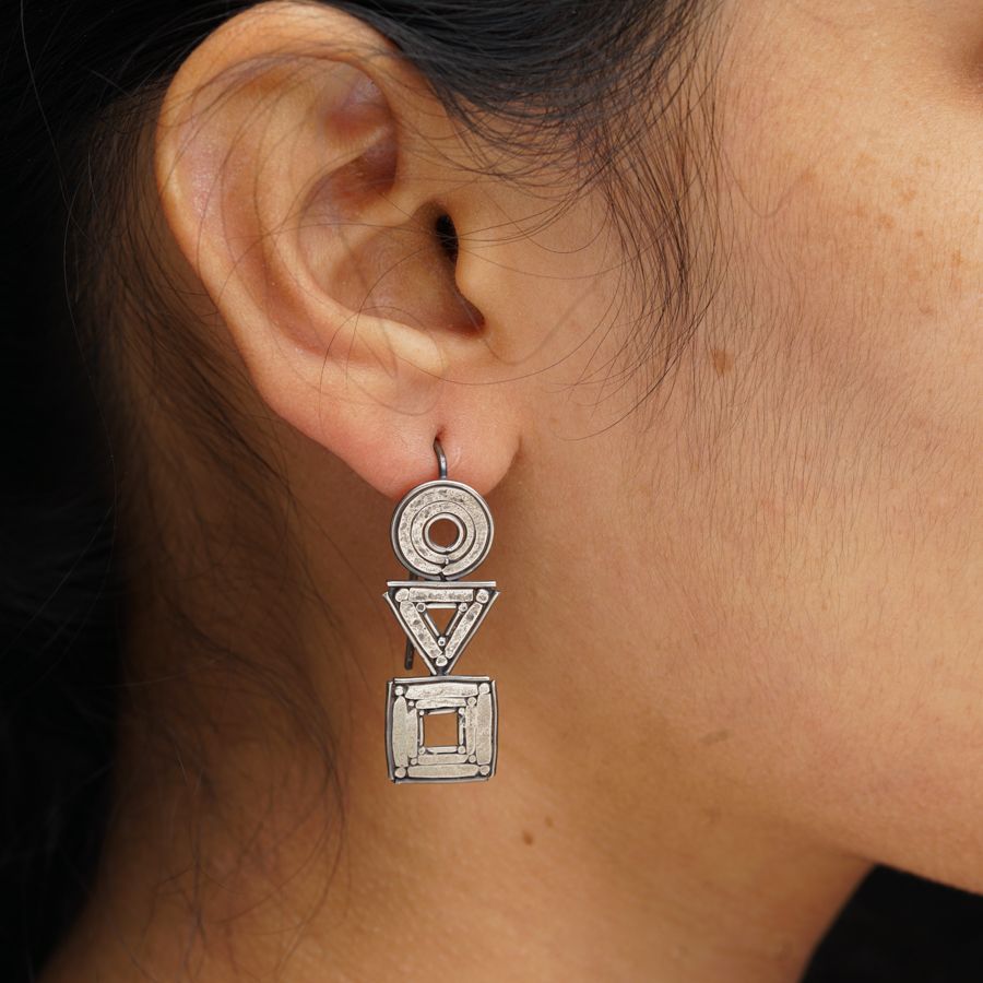 a close up of a person wearing a pair of earrings