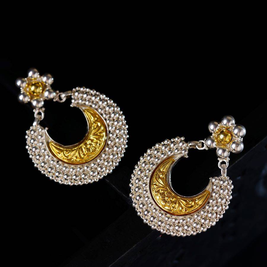 a pair of gold and white earrings
