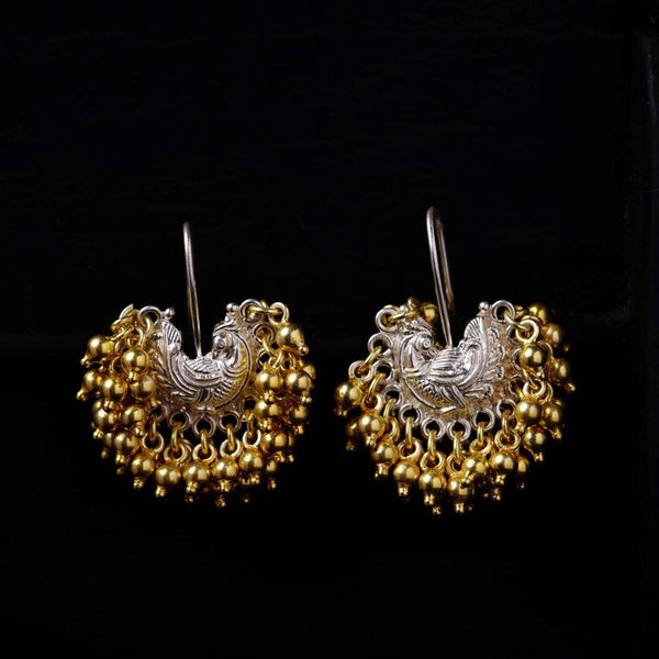 a pair of gold and silver earrings on a black background