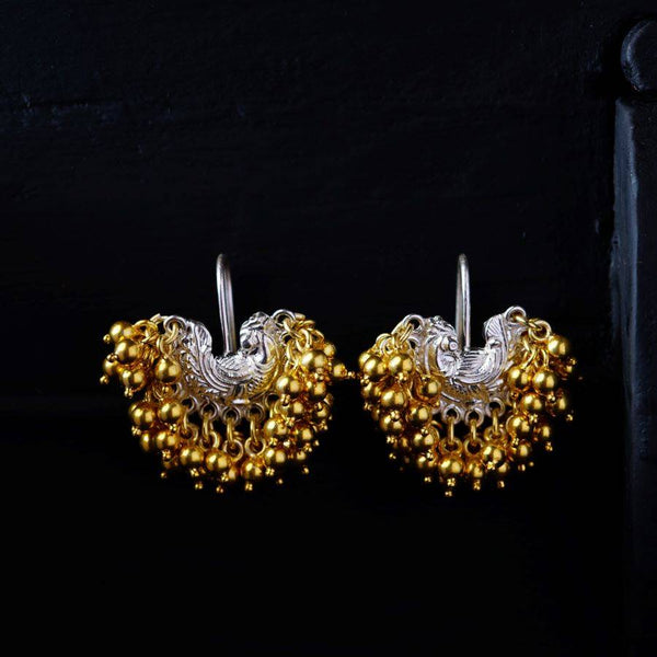 a pair of gold and silver earrings on a black background