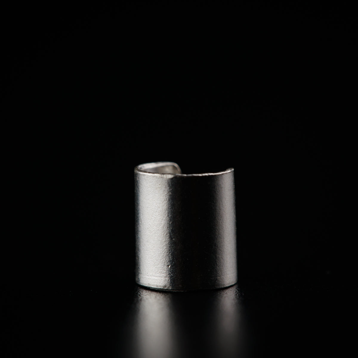 a silver ring sitting on top of a black surface