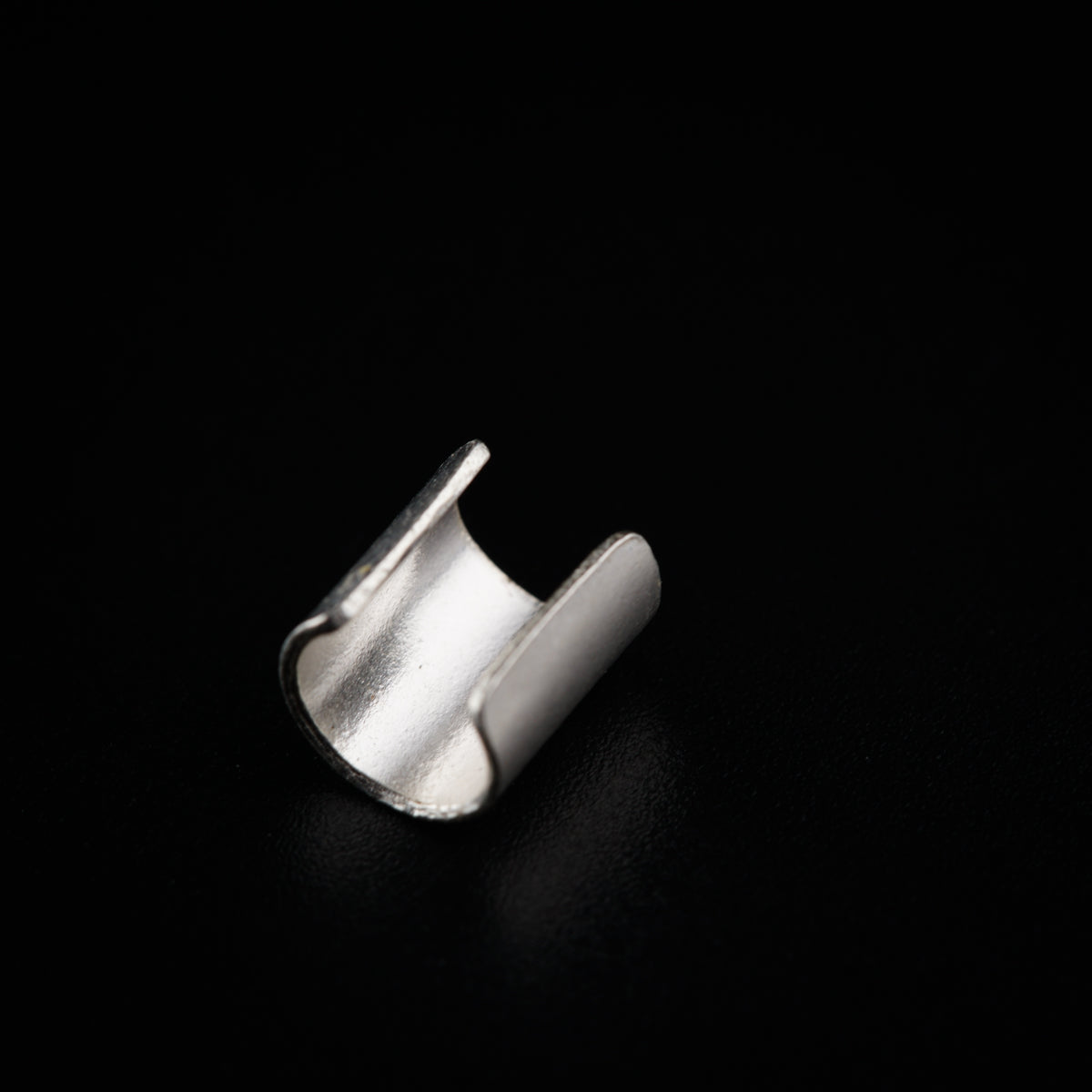 a silver ring sitting on top of a black surface