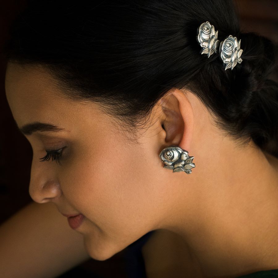 a close up of a person wearing a pair of earrings